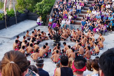 Bali, Endonezya - 10 Aralık 2018: Balili Hindu erkek gösterilerini izleyen turistler Kecak dansı ve kalabalığa müzik draması daha çok Ramayana hikayesiyle ilgili dans ediyor