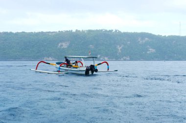 Bali, Endonezya - 07 Aralık 2018: Sürat teknesiyle Nusa Penida denizinde şnorkelle yüzmeye giden turistler. Balıkçı taşımacılığı