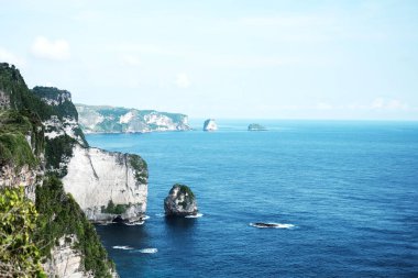 Yazın, Endonezya 'daki Bali adasında okyanus yolculuğu için mavi sakin denizi olan kayalık kayalık kayalık ve vahşi dağ ve tropikal ada