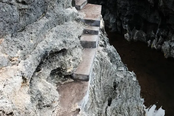 Kayalık kayalıklarda yürümek için eski beton merdivenler ve Endonezya 'nın Bali ve Nehrinde büyük taş dağ