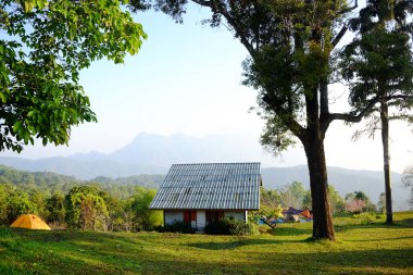 Dağdaki yeşil çimenlikte kalacak yeri ve kamp alanı olan bir ev. Dağın Doi Luang Chiang Dao Dağı manzaralı. Tayland 'ın Chiang Mai Eyaleti.