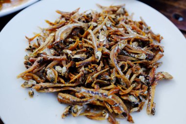 Beyaz tabakta kızarmış ançüez balığı bağırsağı.