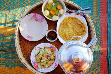 Karıştırılmış lahana ile çırpılmış yumurta ve sıcak pilav ile Tofu çorbası ve evde dokuma sepetinde acı sos. Tayland yemekleri geleneksel kahvaltı veya Tayland 'da akşam yemeği