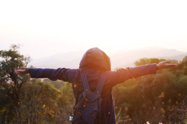 Asyalı genç bir kadın sırt çantası özgürce kollarını açtı ve yaban çiçeğiyle birlikte durdu ve güzel vadi Doi Luang Chiang Dao Dağı, Tayland 'ın Chiang Mai Eyaleti 