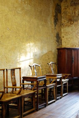 Çin tarzında eski ahşap mobilyaları klasik ve kırsal grunge beton duvarlar ve edebiyat odasında doğal güneş ışığı olan ahşap zemin.