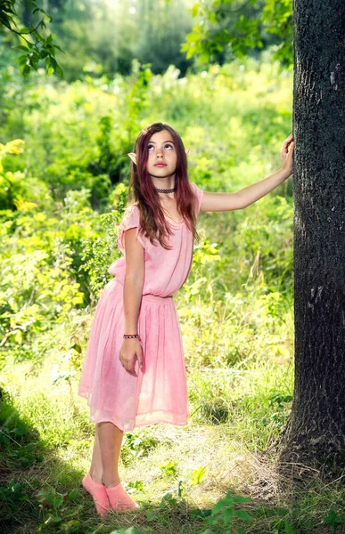 ピンクのドレス 日当たりの良い森 バックライトで自分の耳を持つ素晴らしいイメージの女の子 選択的フォーカス ぼやけた背景 — ストック写真