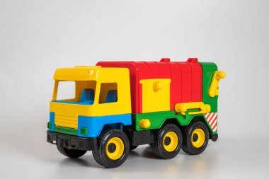 Beyaz arka planda çok renkli plastik çocuk arabaları..