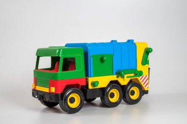 Beyaz arka planda çok renkli plastik çocuk arabaları..