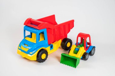 Beyaz arka planda çok renkli plastik çocuk arabaları..