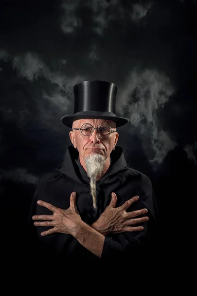 黒の高い帽子と黒の衣を着た謎の男性魔術師の肖像 — ストック写真