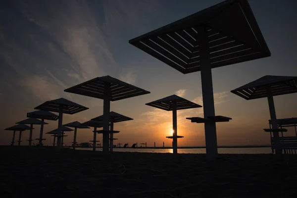 Σιλουέτες Ξύλινες Ομπρέλες Παραλίας Στο Ηλιοβασίλεμα Στην Παραλία — Φωτογραφία Αρχείου