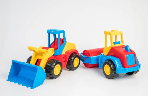 Plastic toy models of construction vehicles. Bulldozer and asphalt roller.