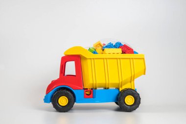Beyaz arka planda çok renkli plastik çocuk arabaları..