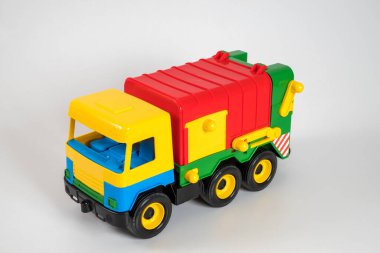 Beyaz arka planda çok renkli plastik çocuk arabaları..