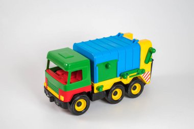 Beyaz arka planda çok renkli plastik çocuk arabaları..