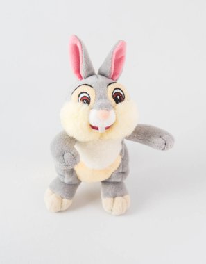 Pembe kulaklı peluş tavşan. Beyaz arka planda çocuklar için yumuşak bir oyuncak.