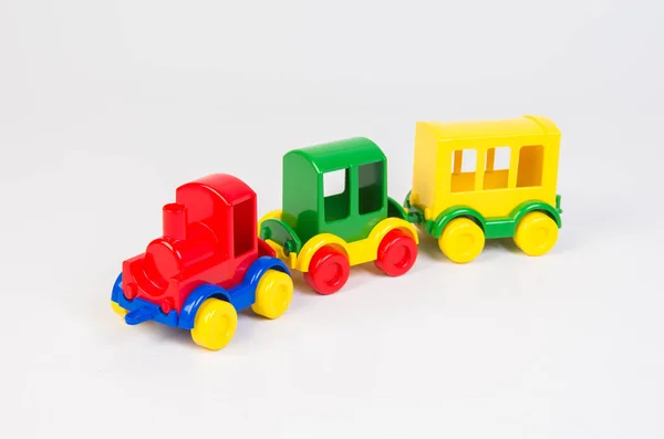 색상의 어린이용 플라스틱 배경에 마차를 다니는 기관차 — 스톡 사진