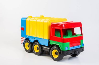 Beyaz arka planda çocuklar için çok renkli plastik oyuncak kamyonlar. Çöp kamyonu.