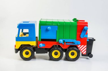 Beyaz arka planda çocuklar için çok renkli plastik oyuncak kamyonlar. Çöp kamyonu.