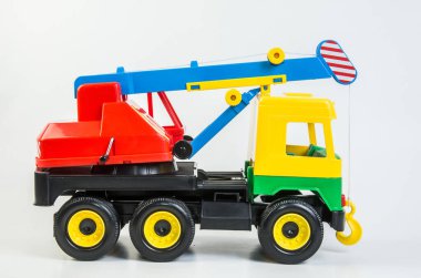 Beyaz arka planda çocuklar için çok renkli plastik oyuncak kamyonlar. Kamyon vinci.