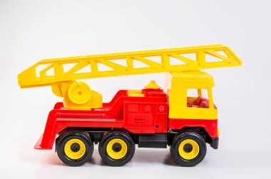 Beyaz arka planda çocuk oyunları için çok renkli plastik oyuncak kamyonlar. Teleskopik antenli itfaiye aracı.