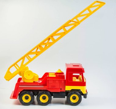 Beyaz arka planda çocuk oyunları için çok renkli plastik oyuncak kamyonlar. Teleskopik antenli kırmızı itfaiye aracı.