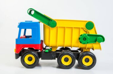 Beyaz arka planda çocuk oyunları için çok renkli plastik oyuncak kamyonlar. Çöp kutusu.