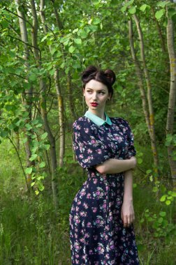 Ağaçların arasında geçmişe dönük bir kız.