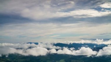 Mavi dağların üzerinde bulutlar belirir.