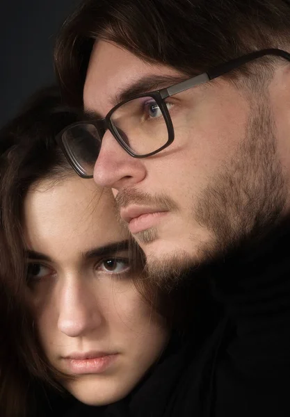 Portrait of a young couple on a black background.