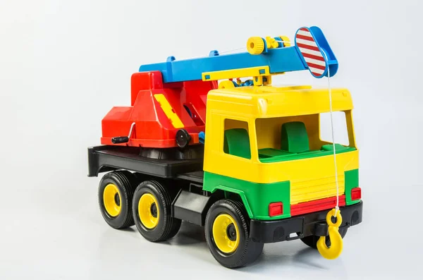 Multi-colored plastic toy trucks for children\'s games on a white background. Truck crane.