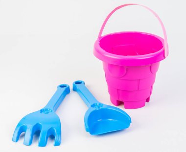Beyaz arka planda kumda oynamak için kürekleri olan çocuk oyuncak kovası..