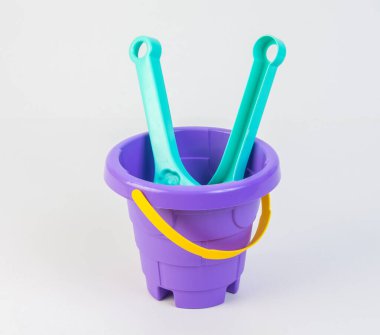 Beyaz arka planda kumda oynamak için kürekleri olan çocuk oyuncak kovası..