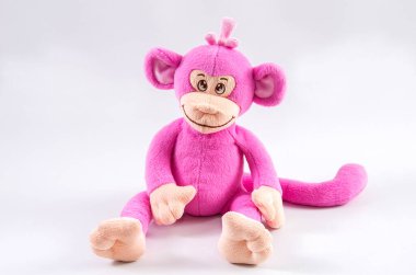 Beyaz arka planda pelüş çocuk oyuncağı pembe maymun.