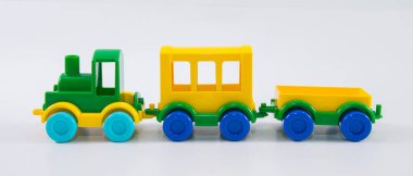 Beyaz arka planda arabaları olan plastik oyuncak tren..