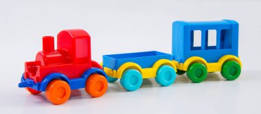 Beyaz arka planda arabaları olan plastik oyuncak tren..