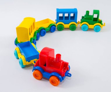 Beyaz arka planda plastik arabaları olan çocuklar..