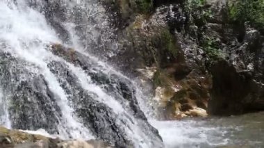 Bir dağ nehrinin taşların arasına düşen suyu..