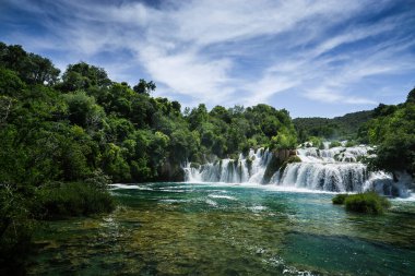 Yeşil yaz ormanlarının arasında şelale.