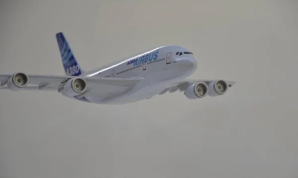 Aircraft model A380 miniature with white and blue paint. White background and base. Copy space. side view