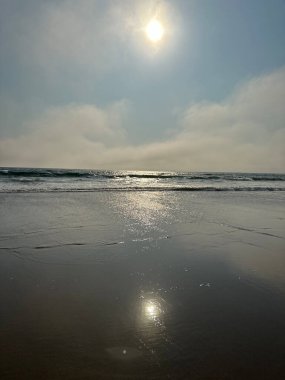 Endonezya 'nın Bali adasında, Canggu sahilinde gün batımının başlangıcı. Ufuk, su, gökyüzü ve güneş ışığının güzel bir kombinasyonu.