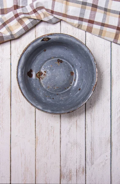 老式搪瓷生锈的碗放在白色的木制书桌上 顶部有格子厨房布 垂直照片 — 图库照片