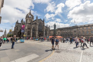 Edinburgh Festivali 2022 kişi Royal Mile 'da St Giles Katedrali' nin arka planında Edinburgh, İskoçya 'daki sokak performansını izliyor.