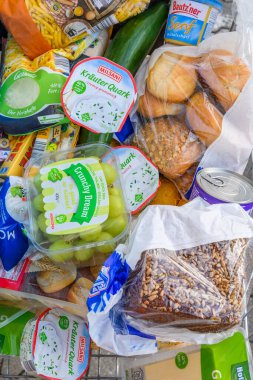 Berlin, Almanya - 27 Ekim 2022: Günlük ihtiyaçlar için çeşitli ürünlerle dolu bir alışveriş arabasına bakın.