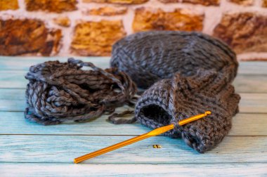 Gri iplik topu ve el ısıtıcısı ile örgü kancası..