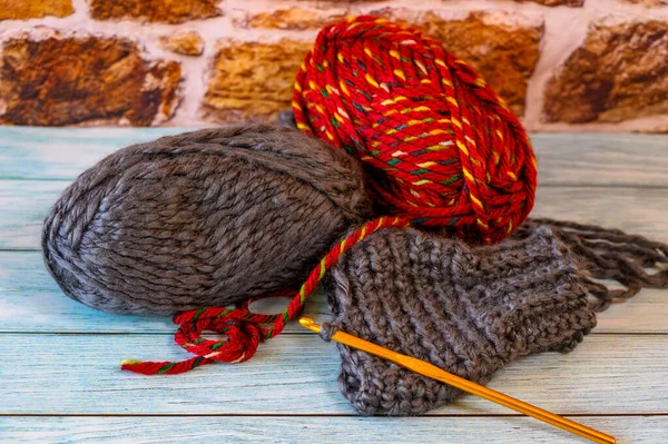 毛糸のいくつかのボールとウールの手を暖かく持つかぎ針編みのフックが始まった — ストック写真