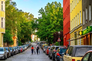 Berlin, Almanya - 28 Haziran 2019: İki bisikletçi Berlin-Kreuzberg şehir merkezindeki bir caddenin ortasında bisikletlerini ittiler.