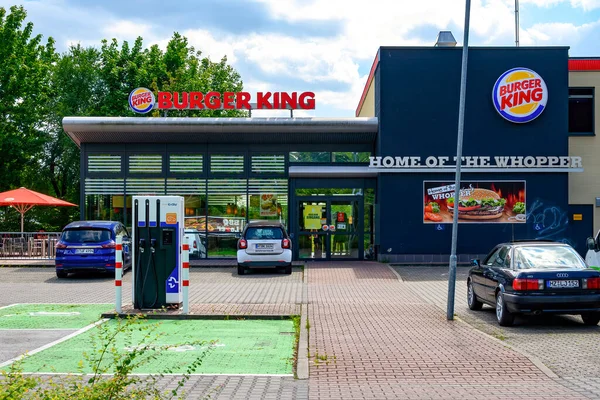 Berlin, Almanya - 6 Ağustos 2021: Bir fast food restoranının giriş alanı ve elektrikli otomobiller için şarj istasyonu.