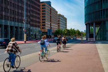 Berlin, Almanya - 8 Mayıs 2020: Berlin şehir merkezindeki Potsdamer Platz 'da bisiklet yolu üzerinde bisikletçiler. 