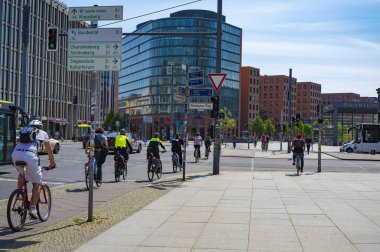 Berlin, Almanya - 8 Mayıs 2020: Berlin şehir merkezindeki Potsdamer Platz 'da bisiklet trafiği. Trafik ışıklarında, bisiklet filosundan iki polis yola çıktı.. 